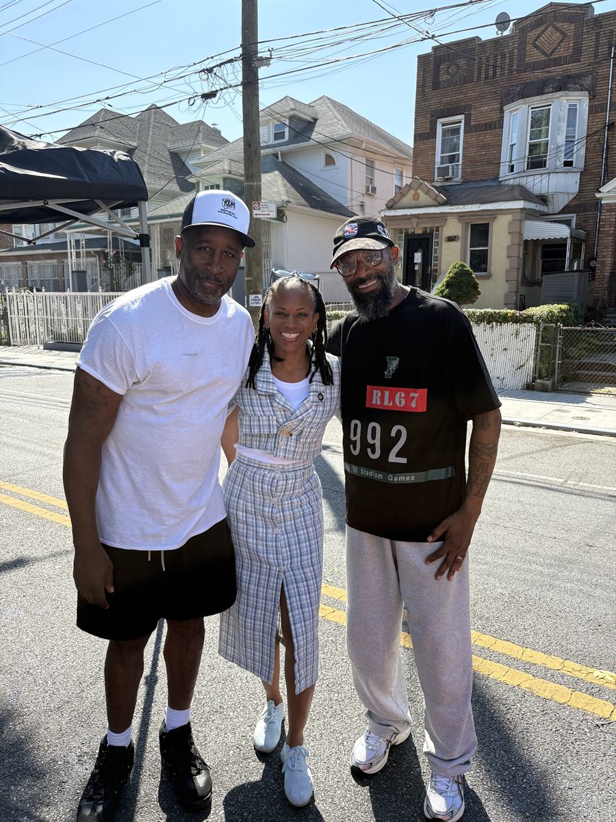 Lamont, a neighbor in a plaid dress and Prance standing together in the middle of the closed avenue