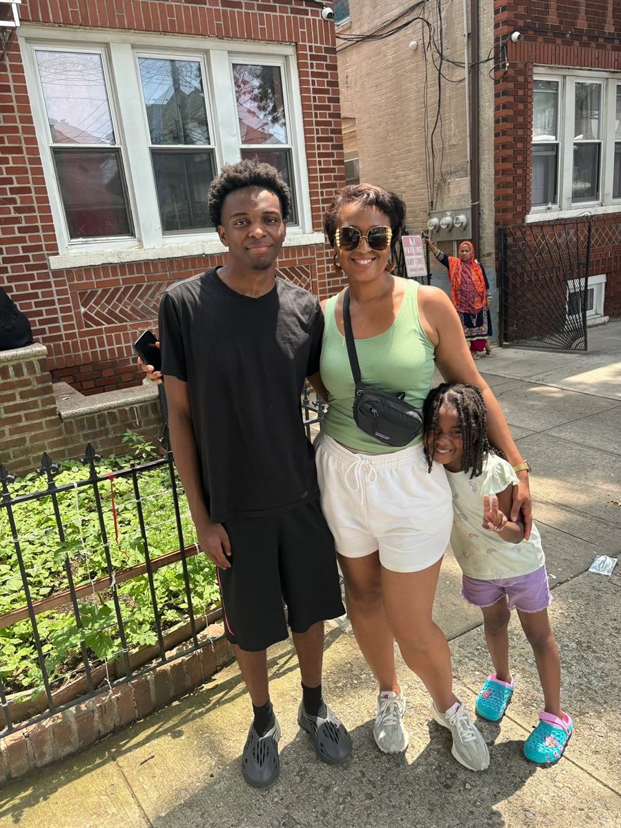 A family standing together on the sidewalk during the block party