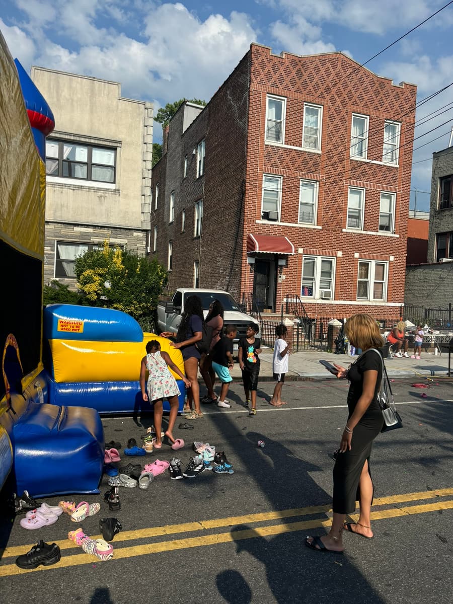 Kids lined up at the inflatable slide on the avenue